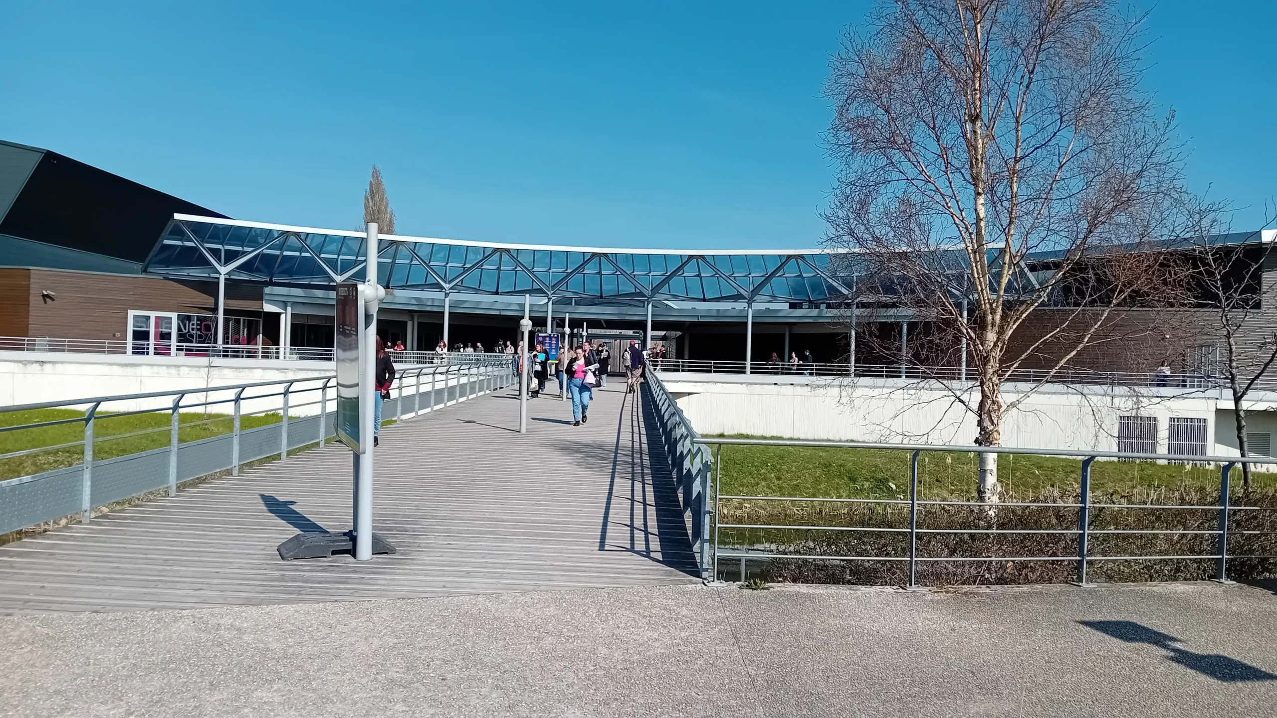 Entrée principale du complexe Scénéo à Longuenesse, lieu du Salon du Travail de Saint-Omer 2025, sous un ciel bleu et ensoleillé.